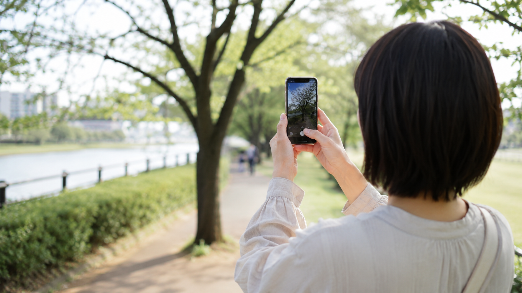 晴れた休日に公園をひとりでのんびり歩いているイメージ